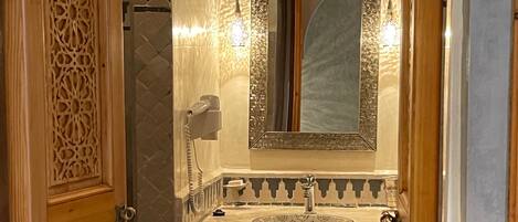 Un baño con lavabo, espejo y ducha.