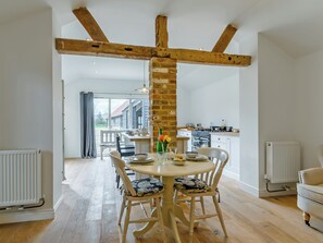 A dining area with a wooden beam ceiling, a brick wall, and a view of the outside. - The Old Dairy At Wooton - UKC4355 (East Chiltington)
