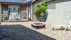 A wooden house with a patio, a small table and chairs, and potted plants. - The Old Dairy At Wooton - UKC4355 (East Chiltington)