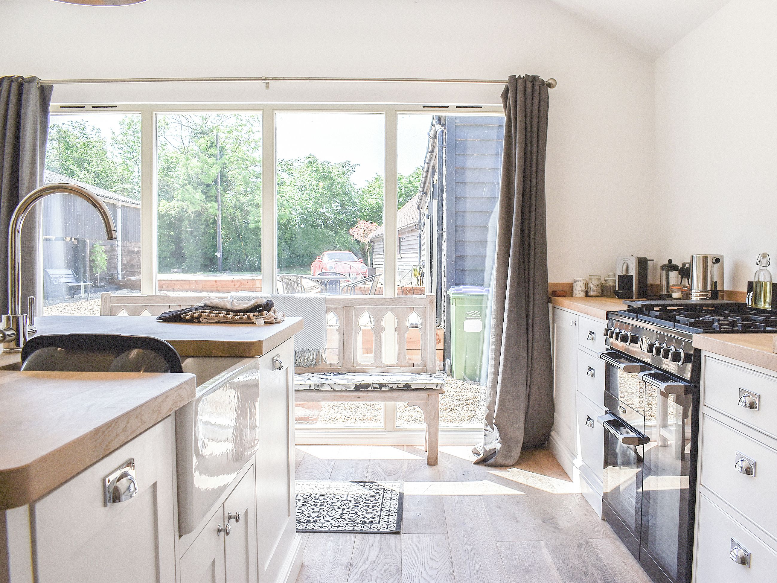 A kitchen with a large window, a dining area, and an attached outdoor space.