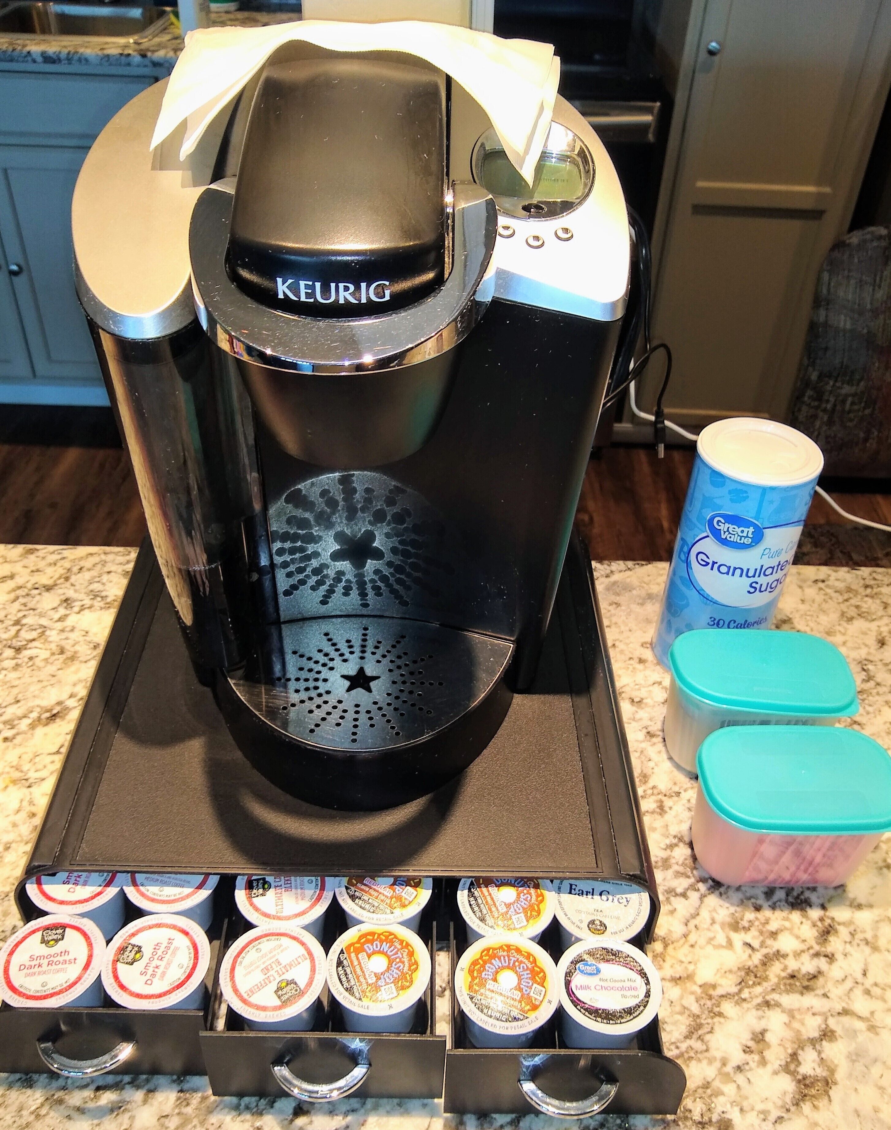 Eine Keurig-Kaffeemaschine mit einem Kaffee-Pod-Halter darunter.