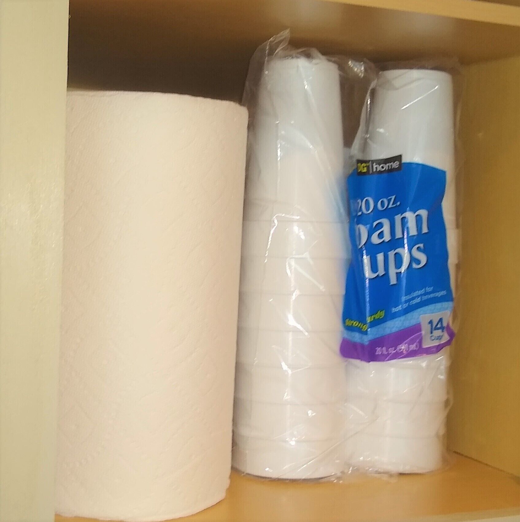 Een plank met twee rollen toiletpapier, een grotere en een kleinere, verpakt in plastic.
