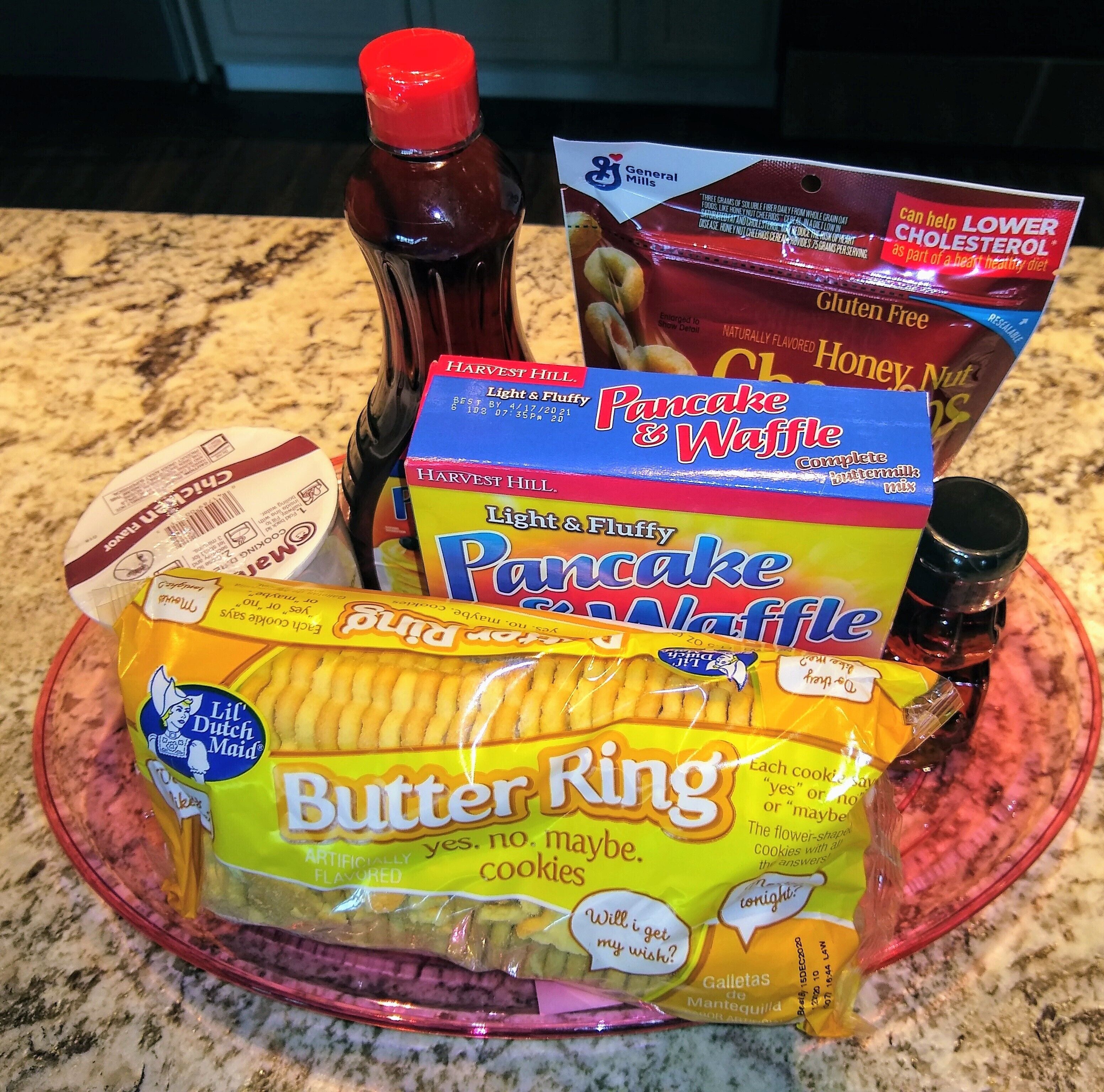 A variety of breakfast items including pancake mix, butter, and a bottle of honey.