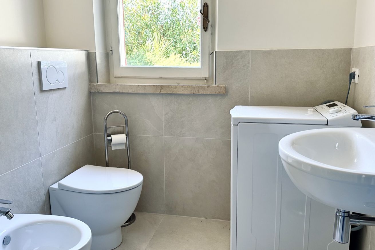 A bathroom with a toilet, bidet, and sink.