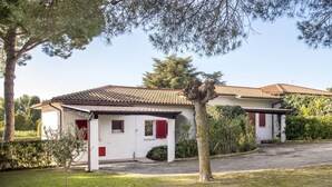 A two-story house with a tiled roof, a small front porch, and a well-maintained lawn. - N081 - Numana, villa with garden (Numana)