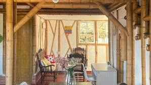 A rustic wooden interior with a table and chairs, a vase with flowers, and a window with a view. - Hotel La Montoya (Curiti)