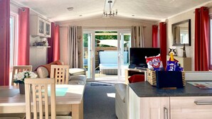 A spacious living area with a sofa, TV, and a dining table.