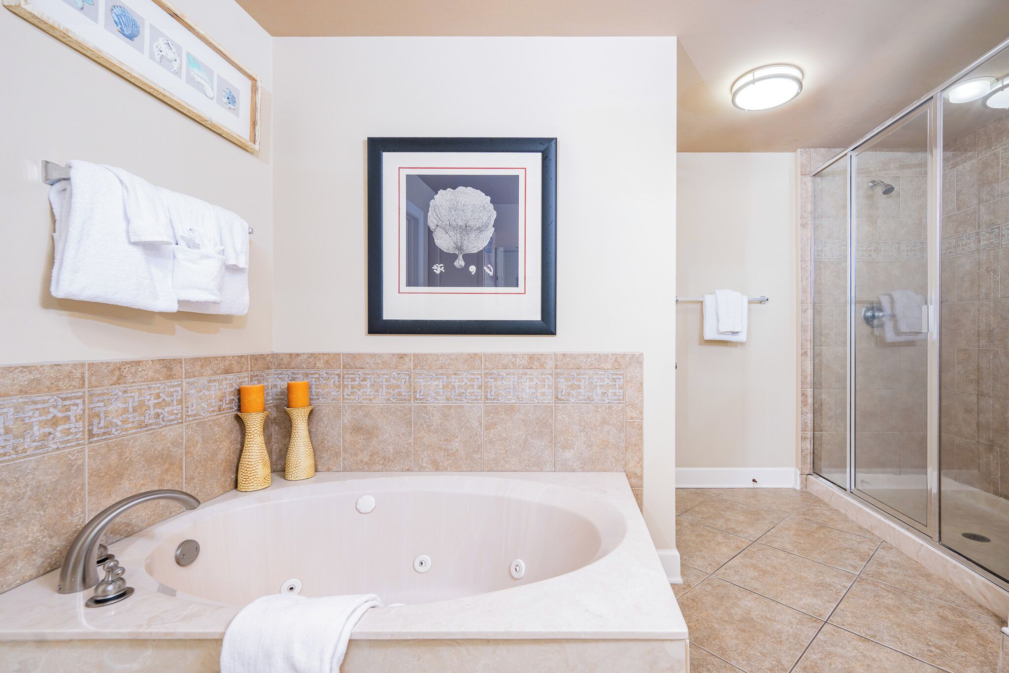 A bathroom with a large bathtub, a shower, and a framed picture on the wall.