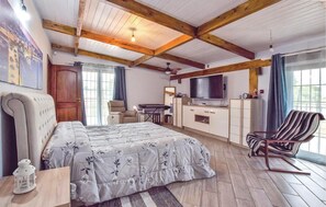 Relax in a spacious bedroom with a large bed, flat-screen TV, and comfortable armchair.