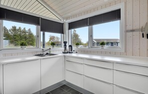 Enjoy cooking in this well-equipped kitchen with a sink, kettle, and ample natural light.