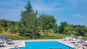 Piscina amb gandules i vistes a arbres i turons.