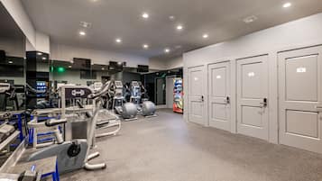 Une salle de sport équipée de matériel d’exercice, d’un distributeur automatique et de casiers.