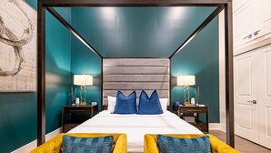 Une chambre à coucher avec un lit à baldaquin, deux tables de chevet et une grande fenêtre.
