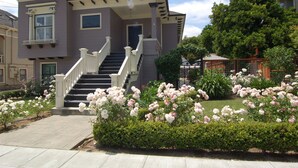 A two-story house with a front porch, a staircase, and a well-maintained garden with pink flowers. - Contemporary Flat w/Gentleman's Vineyard -1 Block to Downtown Napa! Non-Hosted (Napa)