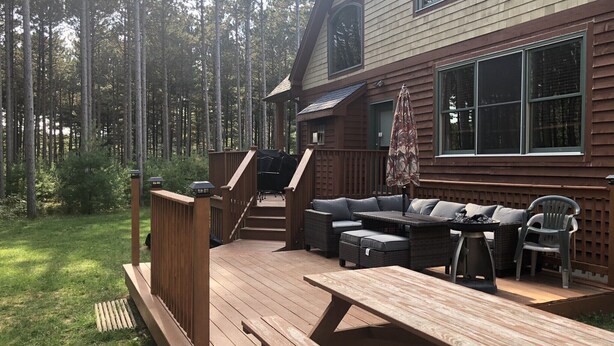 Une terrasse en bois avec un canapé, des chaises et une table.