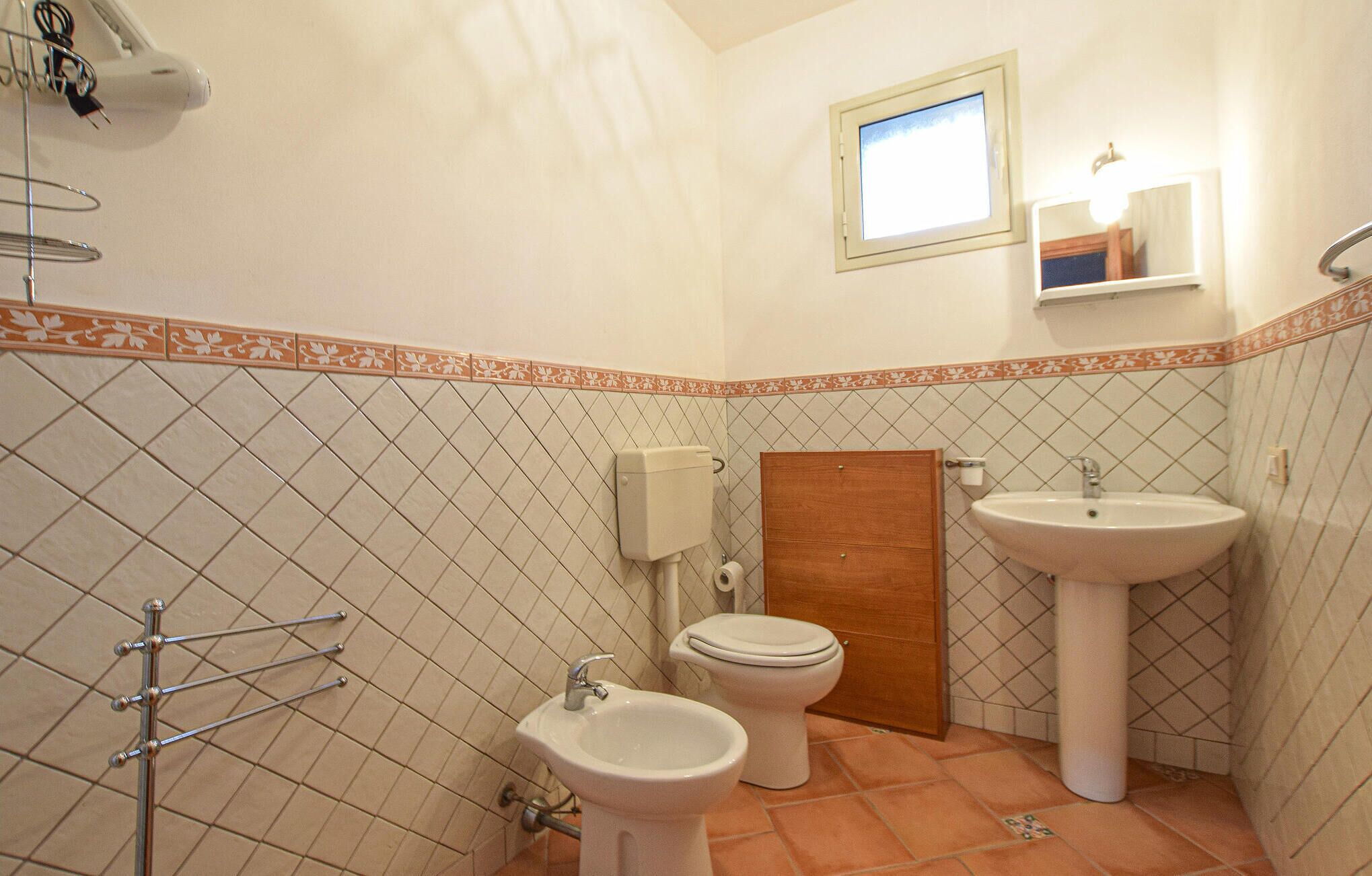 A bathroom with two sinks, a toilet, and a shower.