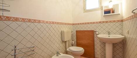A bathroom with two sinks, a toilet, and a shower.
