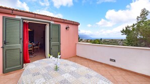 A balcony with a table and chairs, a door leading to a room, and a view of the landscape. - 3 bedroom cozy home in Castellammare del G. (Castellammare del G.)