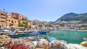 A coastal town with a marina filled with boats, buildings along the waterfront, and a mountain in the background. - 3 bedroom cozy home in Castellammare del G. (Castellammare del G.)