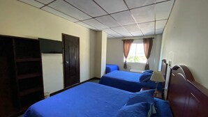 A room with two beds, a wardrobe, a window with curtains, and a ceiling with a grid pattern. - Hotel San Jose (Metapan)