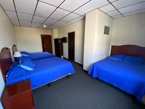 A hotel room with two beds, a desk, a lamp, and a television. - Hotel San Jose (Metapan)