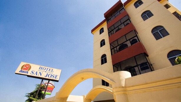 A hotel sign for 'Hotel San Jose' with a clear view of the building's architecture, including its multi-story structure and arched entrance. - Hotel San Jose (Metapan)