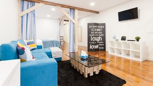 A modern living room with a blue sofa, a glass coffee table, and a motivational quote on the wall. - FLH Graça Artistic Studio (Lisbon)