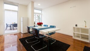 A modern dining area with a white table, blue chairs, and a black rug. - FLH Graça Artistic Studio (Lisbon)