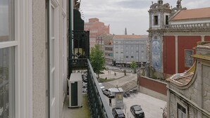 A balcony with a view of a city street, buildings, and parked cars. - FLH Porto Cozy Studio (Oporto)