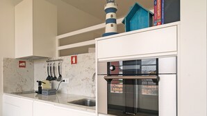 A compact kitchen with a built-in oven and a window overlooking a cityscape. - FLH Porto Cozy Studio (Oporto)