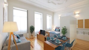 Una sala de estar moderna con un sofá, una mesa de centro, un televisor y un comedor con sillas y una mesa.