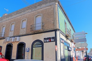 A building with a sign for 'trankilo' and a 'Zona Outlet' sign. - Apartment Canalejas, central location (Tarifa)