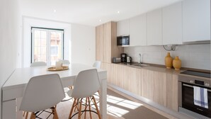Une cuisine moderne avec des meubles blancs, un micro-ondes encastré et un four Bosch.
