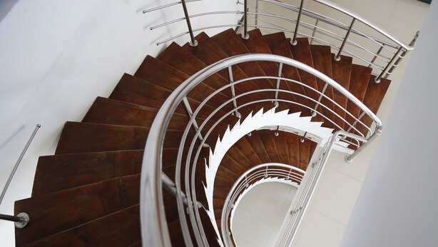 Eine Wendeltreppe mit Holzsitzen und einem Metallgeländer.