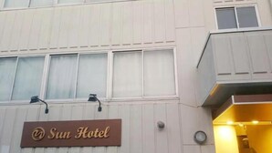 A hotel sign with the name "Sun Hotel" on a building facade. - Sun Hotel (Tokyo)