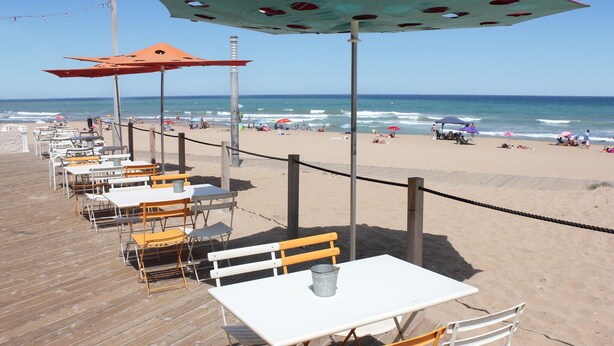 Un restaurante frente a la playa con terraza y vistas al océano.