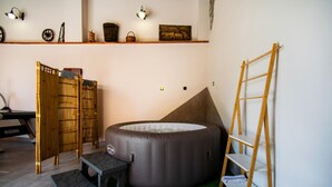A room with a large round inflatable bed, a wooden ladder, a bamboo screen, and a shelf with various items. - 3 bedroom amazing home in Stanjel (Stanjel)
