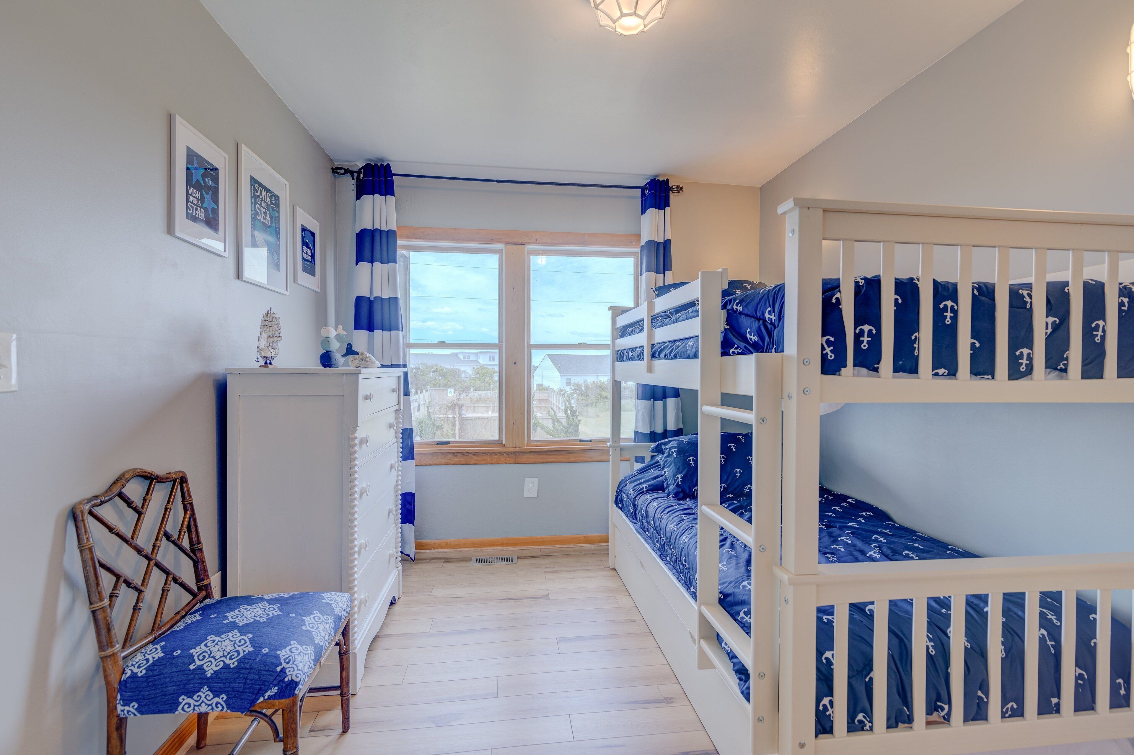 A room with bunk beds, a desk, and a chair.