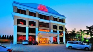 Un hotel de varios pisos con un llamativo letrero de neón que dice 