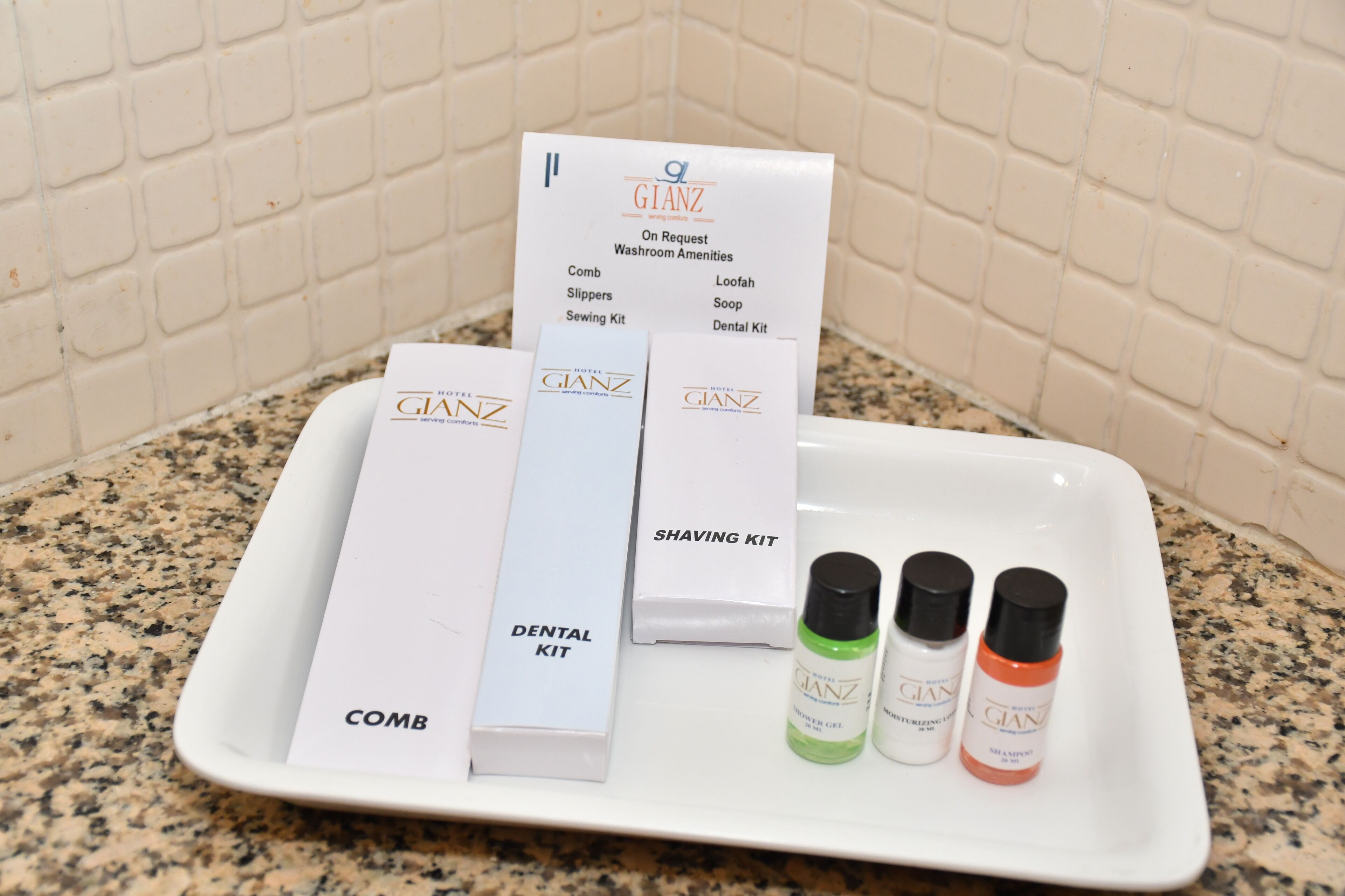 A tray with a dental kit, comb, shaving kit, and grooming products.