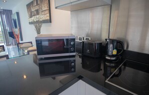 Une cuisine moderne équipée d’un four encastré, d’un grille-pain et d’une machine à café.