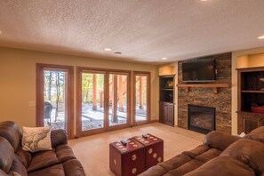 A living room with a fireplace, a television, and a large window. - Lakefront Retreat at Giants Ridge: Golf, Hike, Ski (Biwabik)