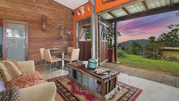 A cozy interior with a wooden wall, a dining area with chairs, a coffee table, and a view of the outdoors. - The Shed Conversion with Hot tub and amazing views: Building#5 (Austinville)