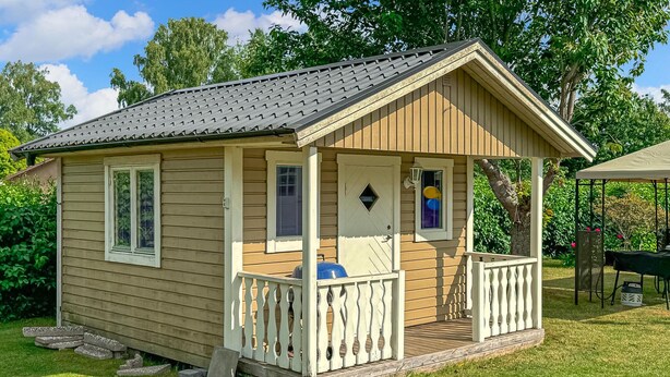 A small wooden cabin with a porch, a door, and a window. - Lovely home in Vimmerby with WiFi (Vimmerby)