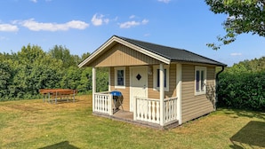 A small wooden cabin with a porch, a bench, and a grill. - Lovely home in Vimmerby with WiFi (Vimmerby)