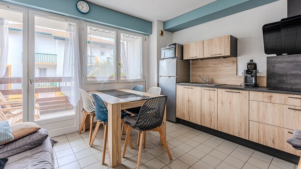 Una cocina moderna con armarios de madera, horno empotrado y cafetera.