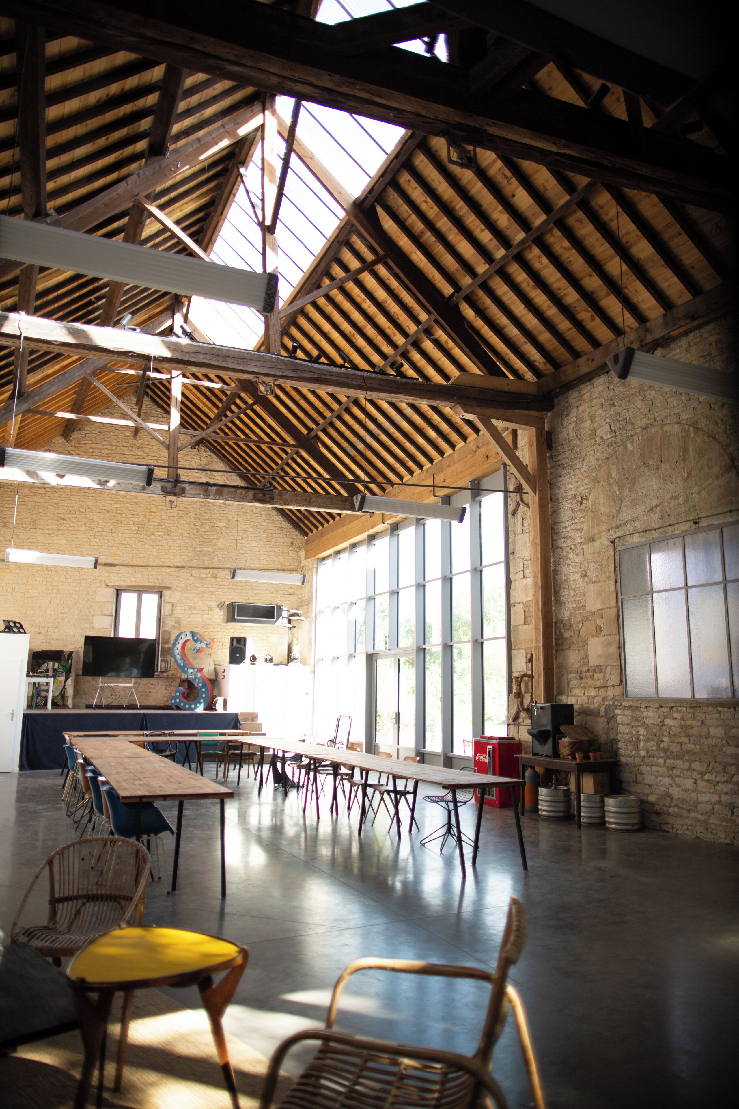 Un vaste hall doté de hauts plafonds, de grandes fenêtres et d’une longue table entourée de chaises.