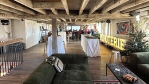 A rustic interior with wooden beams, tables with white tablecloths, a green sofa, and a Christmas tree. - Former flour mill 20 minutes from La Rochelle: sleeps 15 to 25 (mauzé on the mignon)