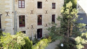 A stone building with multiple windows and a tree in the foreground. - Former flour mill 20 minutes from La Rochelle: sleeps 15 to 25 (mauzé on the mignon)