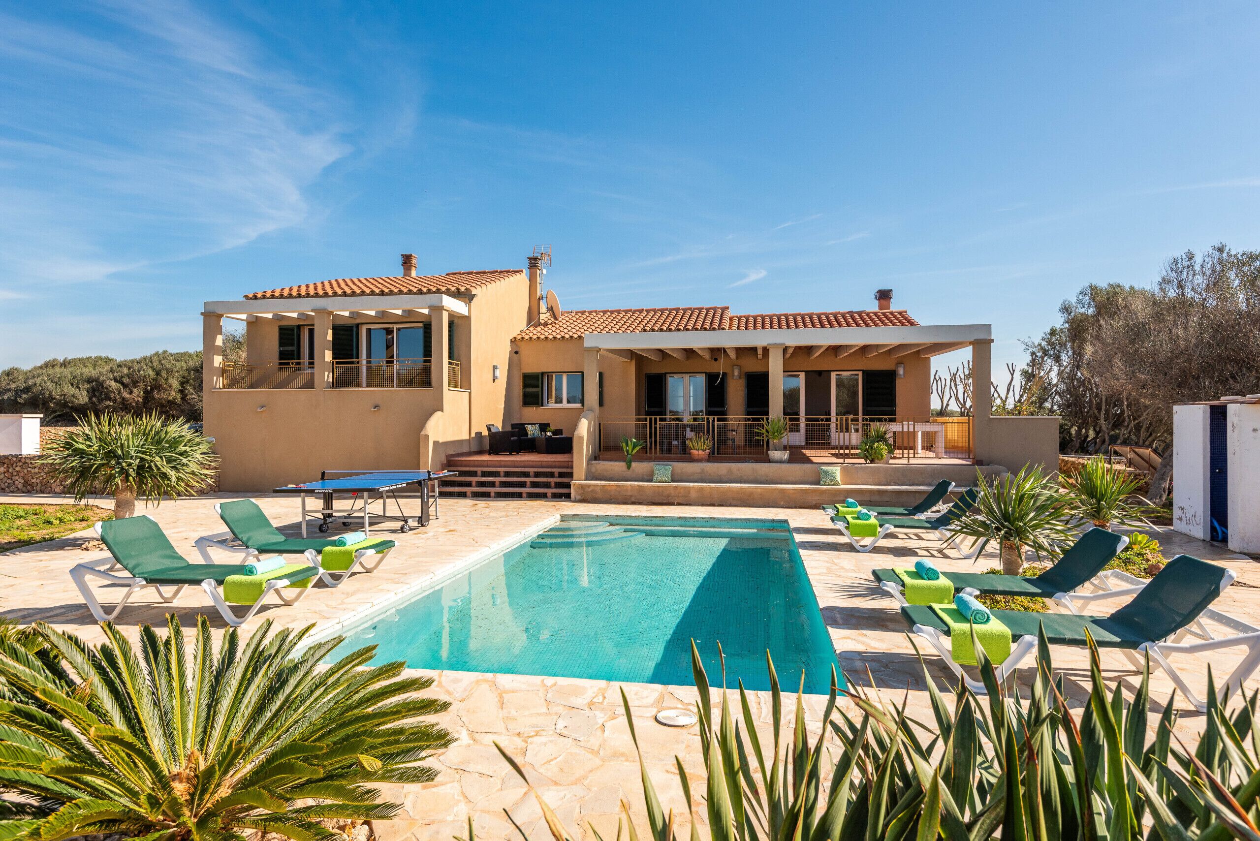 Une maison moderne dotée d’une piscine, d’un espace salon extérieur et d’un patio.
